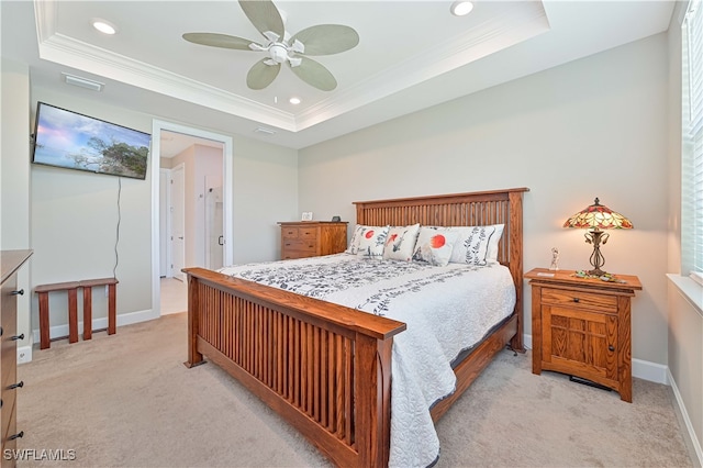 bedroom featuring light carpet, a tray ceiling, ornamental molding, and ceiling fan