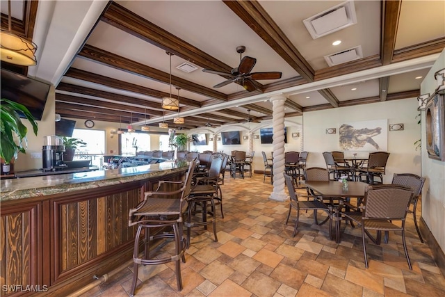 dining area featuring beamed ceiling and ceiling fan