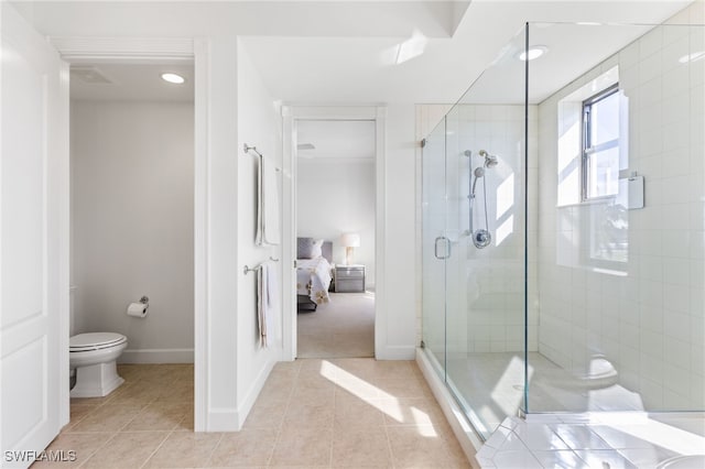 ensuite bathroom featuring baseboards, toilet, ensuite bathroom, tile patterned flooring, and a shower stall