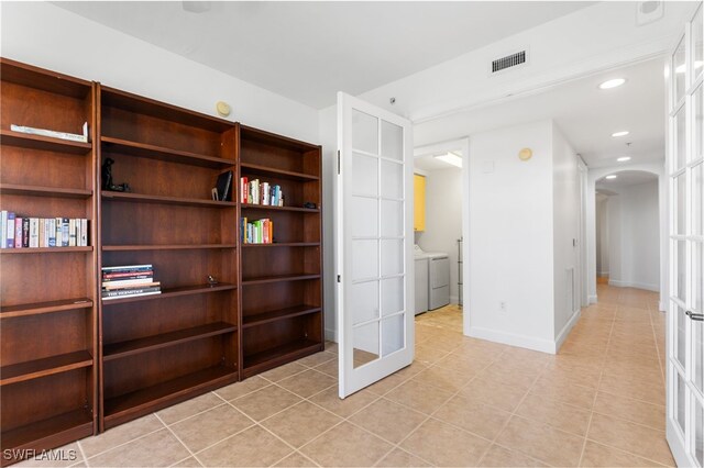 interior space with visible vents, arched walkways, baseboards, washing machine and dryer, and recessed lighting