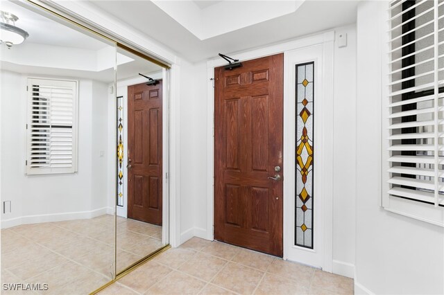 tiled foyer featuring a raised ceiling