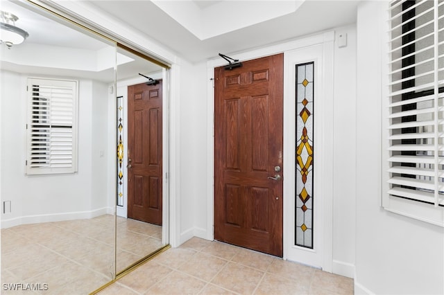 foyer featuring light tile patterned floors and baseboards