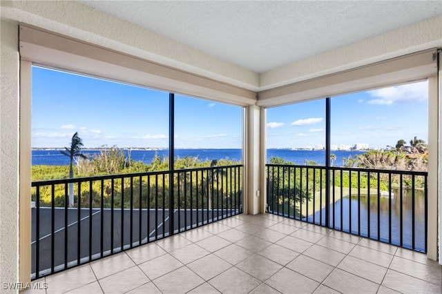 unfurnished sunroom featuring a water view