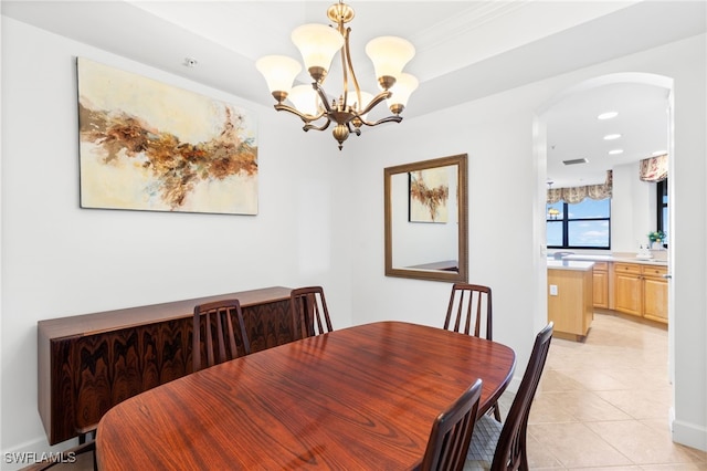 dining area with arched walkways, an inviting chandelier, recessed lighting, and light tile patterned floors