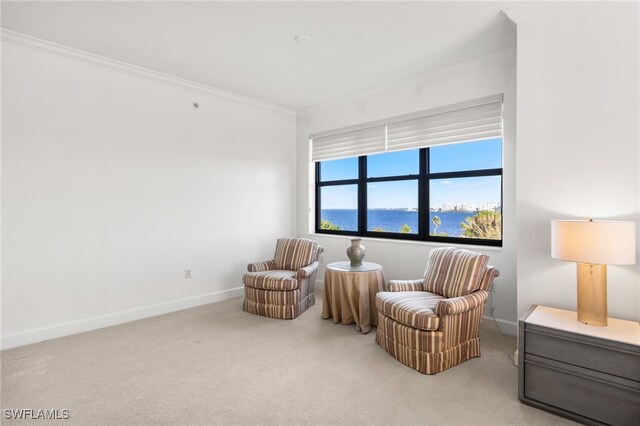 living area with a water view, carpet, baseboards, and crown molding