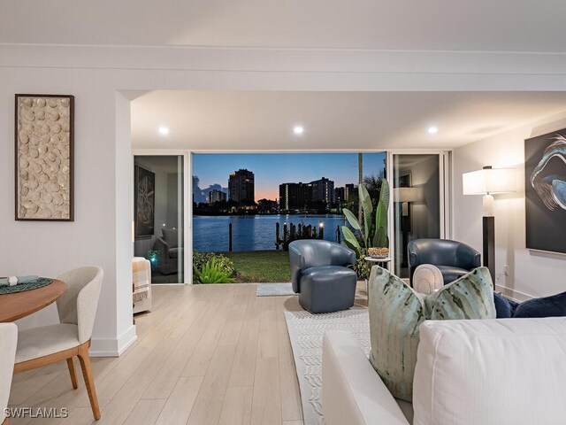 living room with wood-type flooring and a water view