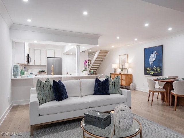 living room featuring ornamental molding and light hardwood / wood-style floors