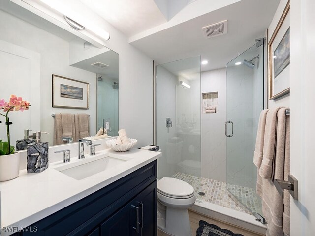 bathroom featuring walk in shower, vanity, and toilet