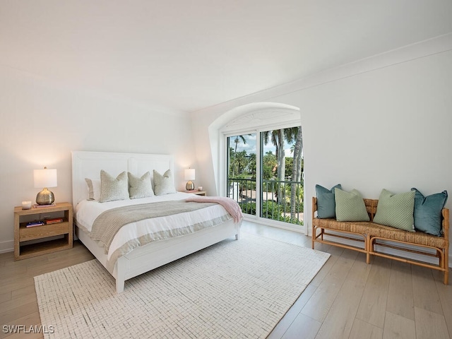 bedroom featuring access to exterior and light wood-type flooring