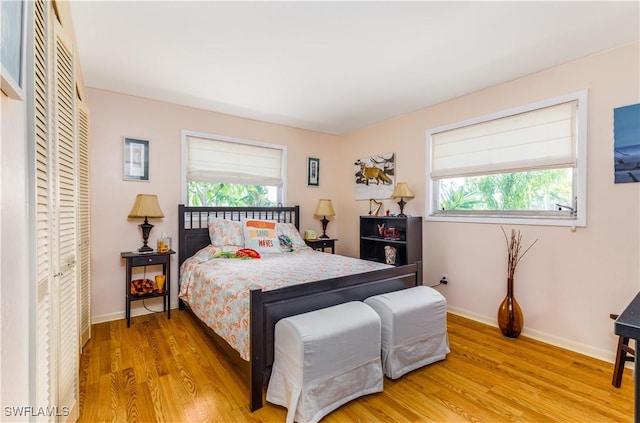 bedroom with multiple windows and light hardwood / wood-style flooring