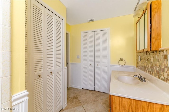 bathroom featuring vanity, backsplash, and tile patterned floors