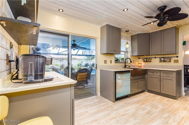 kitchen featuring hanging light fixtures, ceiling fan, white dishwasher, light hardwood / wood-style floors, and wooden ceiling