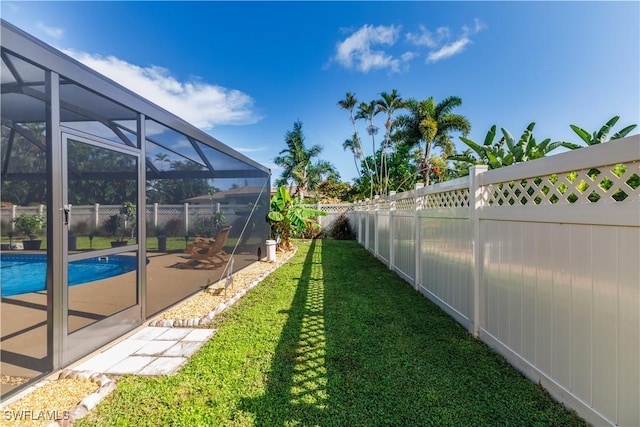 view of yard featuring a fenced in pool and glass enclosure