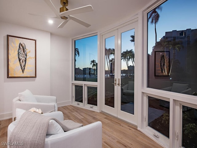 living area with ceiling fan and light hardwood / wood-style floors