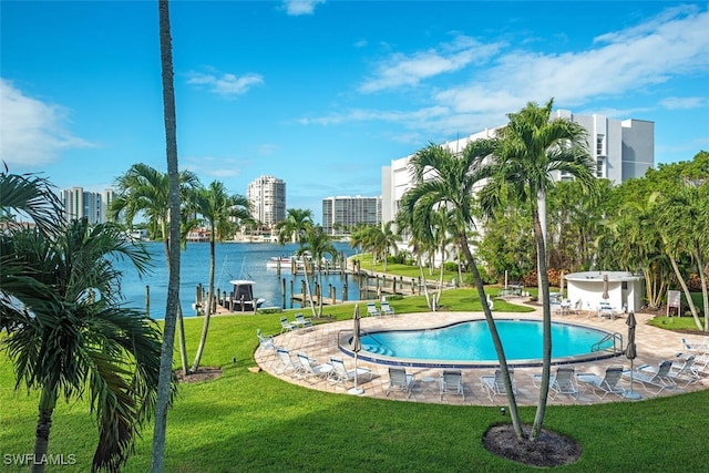 view of pool with a water view and a yard