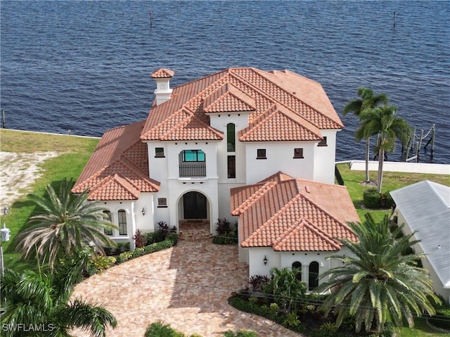 exterior space with a balcony, a water view, and a yard