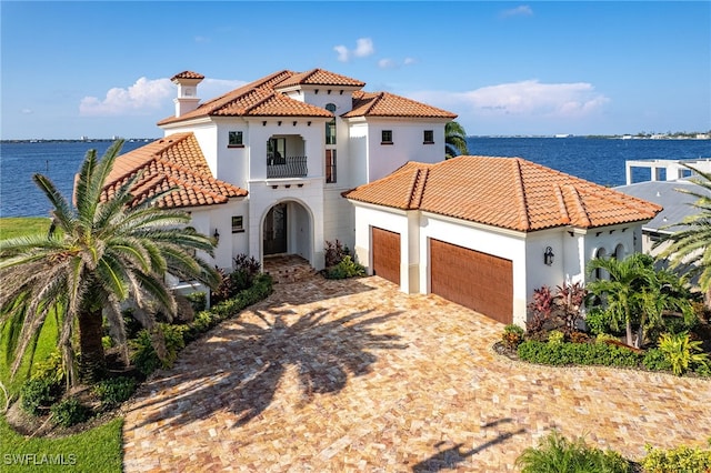 614 Coral Dr, Cape Coral, FL 33904 - mediterranean / spanish house with a balcony, stucco siding, decorative driveway, a tile roof, and a garage
