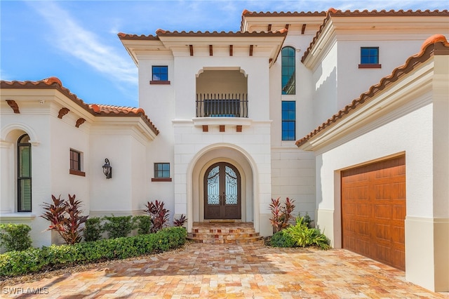 614 Coral Dr, Cape Coral, FL 33904 - entrance to property featuring stucco siding, french doors, decorative driveway, a garage, and a tiled roof