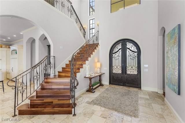 614 Coral Dr, Cape Coral, FL 33904 - entrance foyer featuring french doors, baseboards, stone tile flooring, and stairway