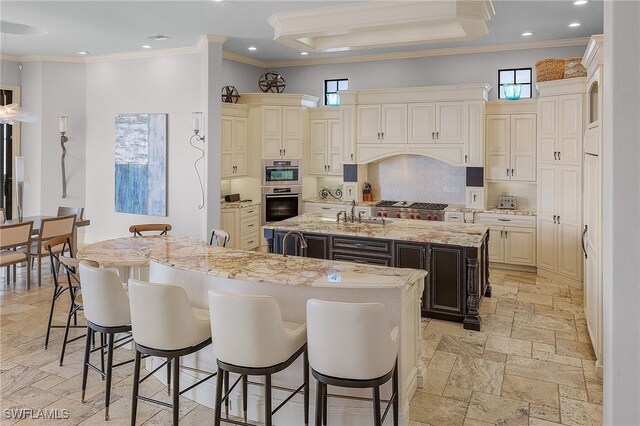 614 Coral Dr, Cape Coral, FL 33904 - kitchen featuring backsplash, cream cabinets, crown molding, a spacious island, and stone tile floors