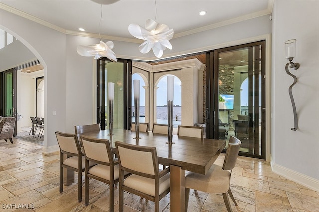 614 Coral Dr, Cape Coral, FL 33904 - dining area with baseboards, arched walkways, stone tile flooring, crown molding, and recessed lighting