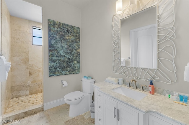 bathroom with tiled shower, vanity, and toilet