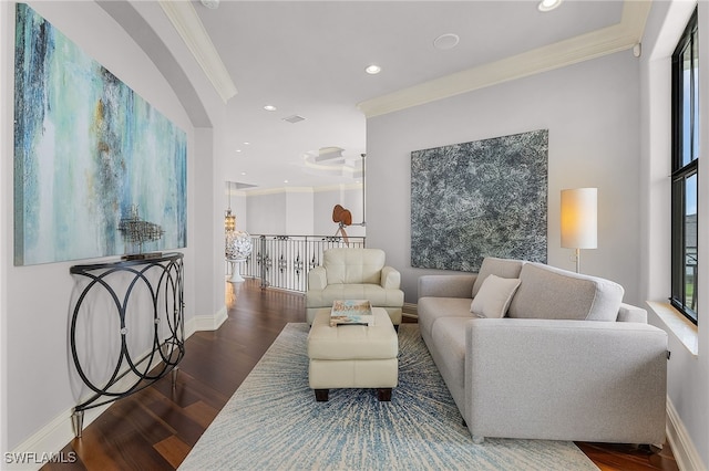 living room with dark hardwood / wood-style floors, ornamental molding, and a healthy amount of sunlight