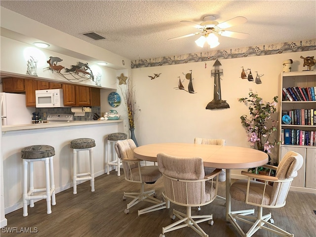 dining area featuring ceiling fan, hardwood / wood-style flooring, and a textured ceiling