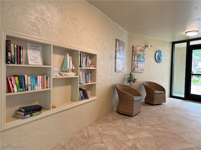 sitting room with light tile patterned floors and built in features