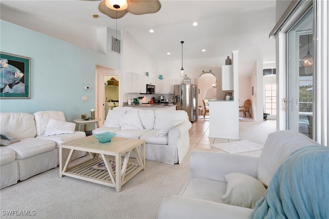 living room with ceiling fan, high vaulted ceiling, and light colored carpet