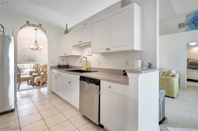 kitchen featuring a chandelier, appliances with stainless steel finishes, vaulted ceiling, sink, and light colored carpet