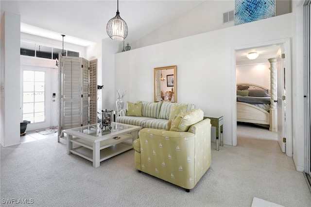 carpeted living room featuring vaulted ceiling and an inviting chandelier