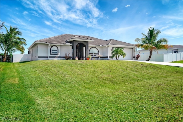 mediterranean / spanish home featuring a front lawn and a garage