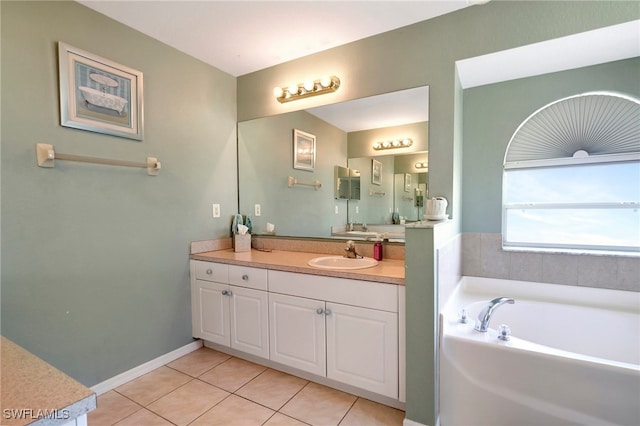 bathroom with tile patterned floors, a tub, and vanity