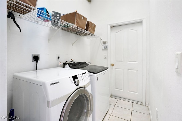 laundry room with light tile patterned floors and washing machine and clothes dryer