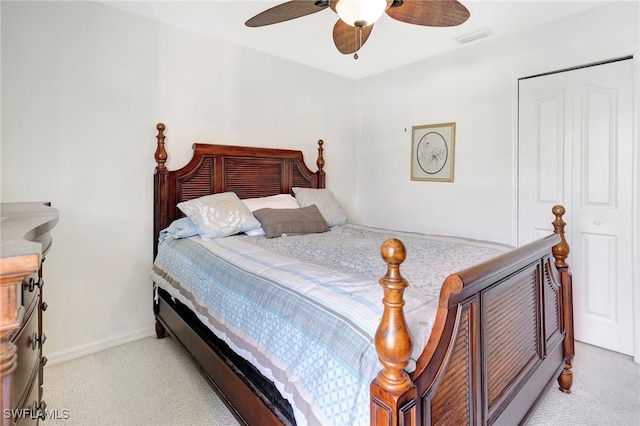 bedroom with ceiling fan, light carpet, and a closet