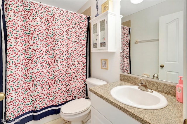 bathroom with toilet, vanity, and tile patterned flooring