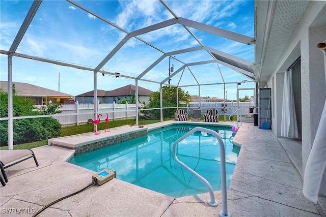 view of swimming pool featuring glass enclosure and a patio