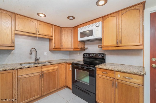 kitchen with sink, light tile patterned floors, light stone counters, and black range with electric cooktop