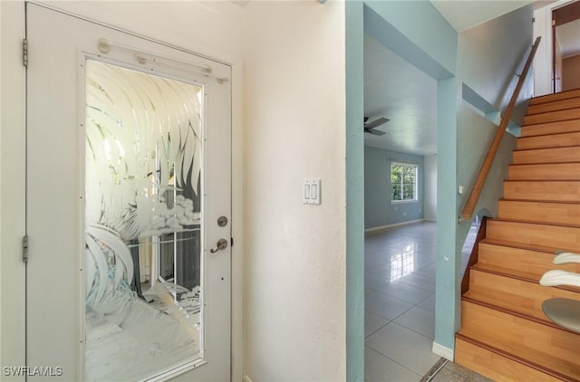 doorway to outside featuring light tile patterned floors and ceiling fan