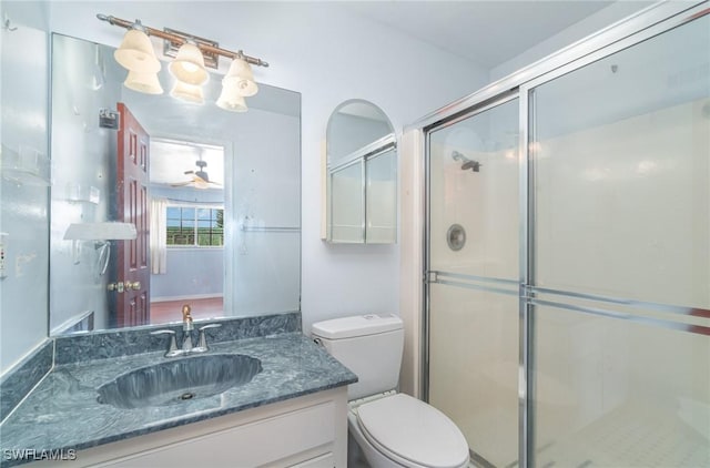 bathroom featuring walk in shower, ceiling fan, vanity, and toilet