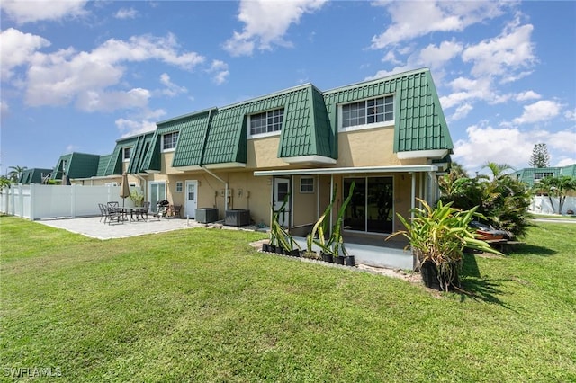 rear view of property with a patio, cooling unit, and a lawn