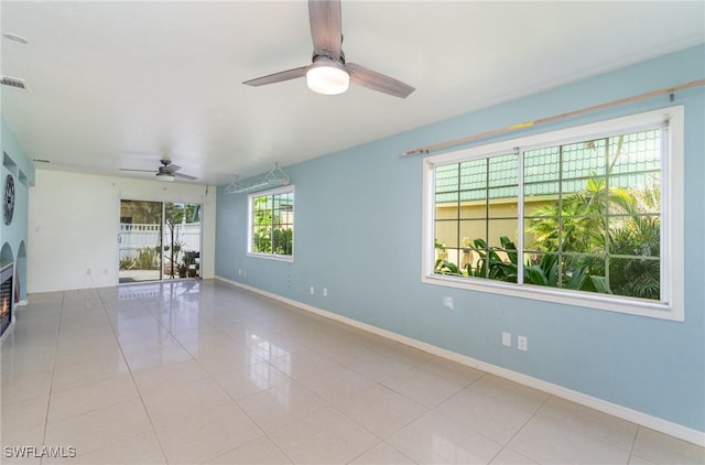 tiled spare room featuring ceiling fan