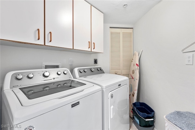 washroom featuring cabinets and separate washer and dryer