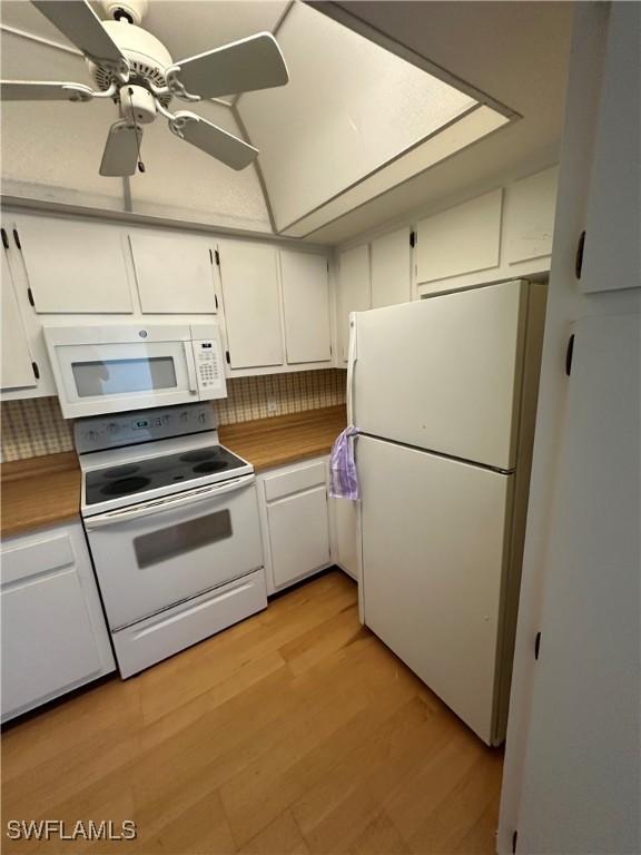 kitchen featuring white appliances, light hardwood / wood-style flooring, white cabinets, ceiling fan, and backsplash