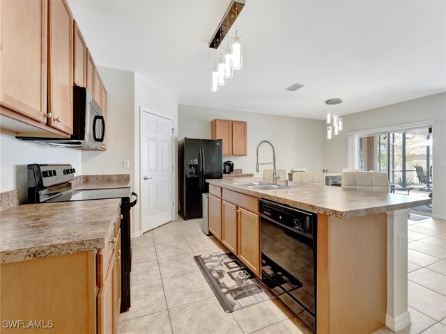 kitchen featuring pendant lighting, black appliances, an island with sink, sink, and light tile patterned floors