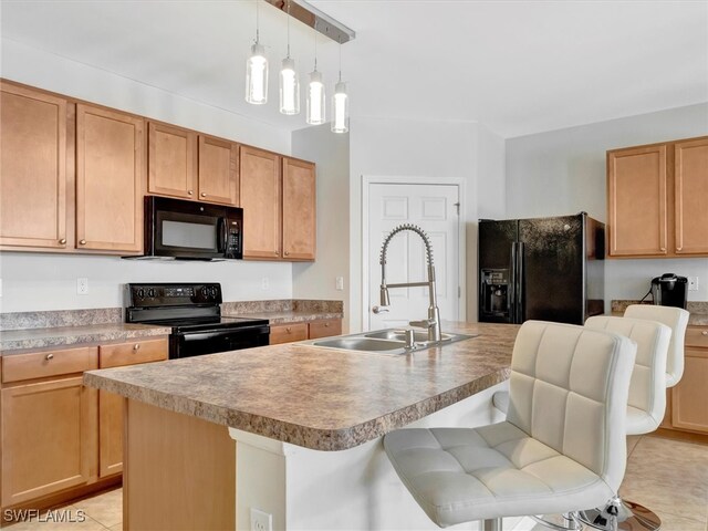 kitchen with sink, black appliances, a center island with sink, and a breakfast bar area