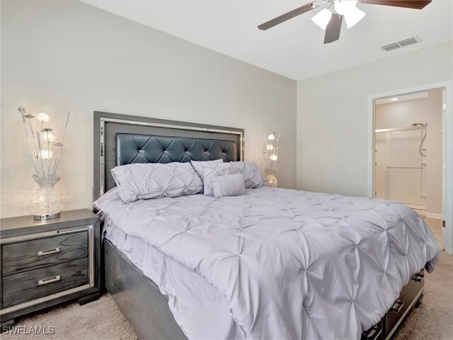 carpeted bedroom with ensuite bath and ceiling fan