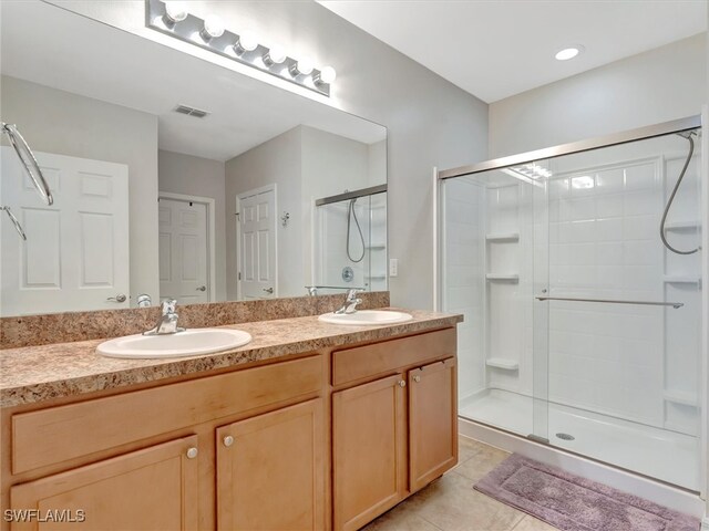 bathroom with walk in shower, tile patterned floors, and vanity