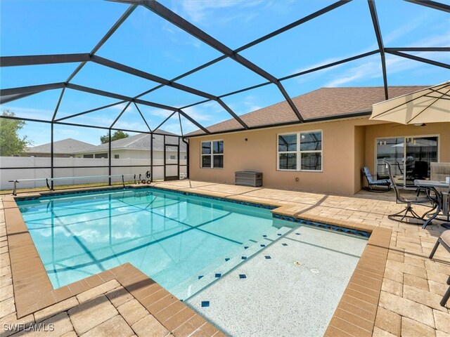 view of swimming pool featuring a patio area and a lanai